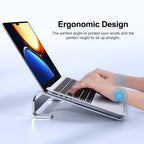 Manos escribiendo en laptop sobre soporte elevador de aluminio ergonómico, texto: Diseño ergonómico, el ángulo perfecto para proteger tus muñecas y la altura ideal para mantener la espalda recta